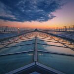 Dramatic perspective of modern glass architecture with sunset reflections.