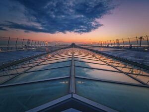Dramatic perspective of modern glass architecture with sunset reflections.