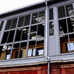 Image of a modern train station exterior, showcasing reflective windows and urban architecture.