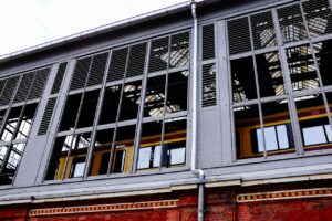 Image of a modern train station exterior, showcasing reflective windows and urban architecture.