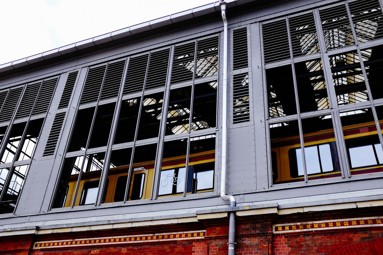 Image of a modern train station exterior, showcasing reflective windows and urban architecture.