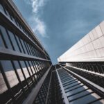 Low-angle view of sleek modern glass skyscrapers against a blue sky in Germany.