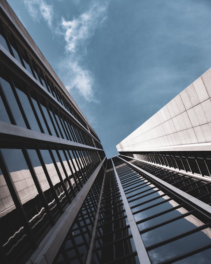 Low-angle view of sleek modern glass skyscrapers against a blue sky in Germany.
